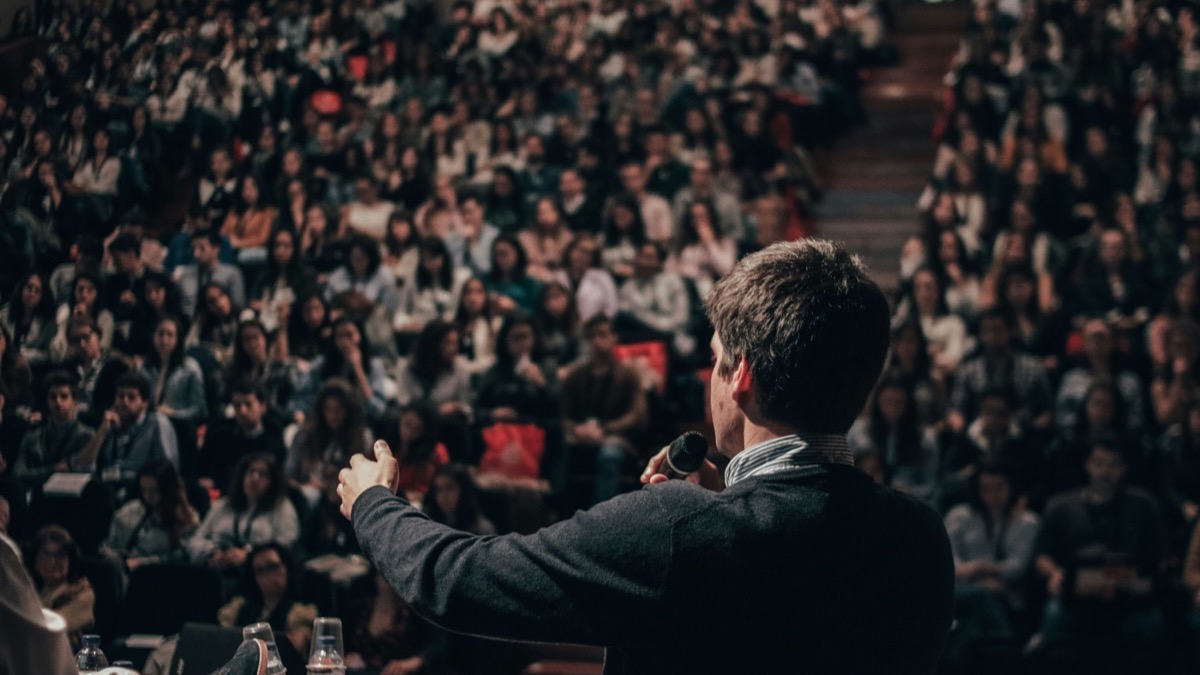 Speaker presenting on stage to an audience